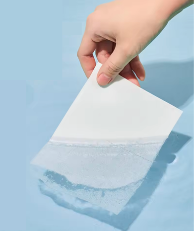 Laundry sheet being placed in water and easily dissolving